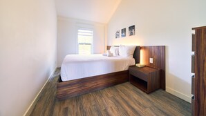 Een slaapkamer met een houten hoofdbord, een nachtkastje en een bedtafel.