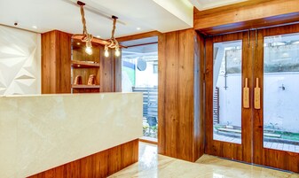 Un área de recepción moderna con paneles de madera, una barra de mármol y una lámpara de cuerda original.