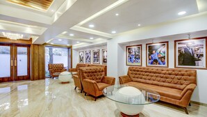 Ein modernes Wohnzimmer mit Ledersofas, einem Glastisch und gerahmten Sportmemorabilien an der Wand.