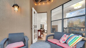 An outdoor seating area with wicker furniture and a small round table.