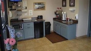Une cuisine compacte équipée d’un four à micro-ondes, d’une machine à café et d’un petit réfrigérateur.