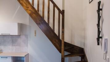 A wooden staircase with a modern pendant light fixture.