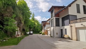 Une rue résidentielle bordée de maisons, avec une voiture garée et un ciel dégagé.
