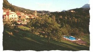 A hillside village with buildings, a church, and a swimming pool. - Apartment/ flat - Sermezzana (Minucciano)