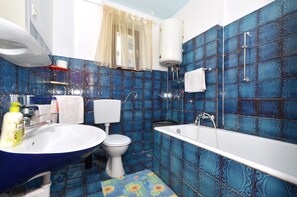 A bathroom with a blue tiled wall, a white toilet, a white sink, and a bathtub. - C - apt w. Balcony, Shared Terrace & the sea View (Trogir)