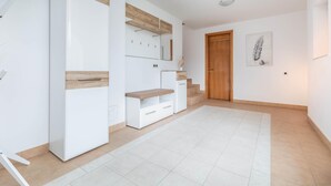 Una habitación amplia con un armario grande, un banco y una escalera que sube a otro nivel.