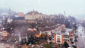 A historic town with a prominent castle on a hill, surrounded by residential buildings and a main road. - MOLDO HOUSE, "CASA MOLDO", AT THE FOOT OF THE MEDIEVAL FORTRESS, CENTRAL (Sighișoara)