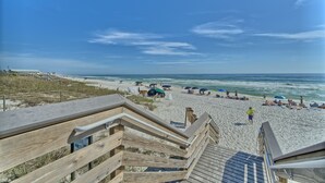 A wooden boardwalk leading to a sandy beach with umbrellas and people. - Hangtime Inlet Beach/Next to Rosemary Beach (Inlet Beach)