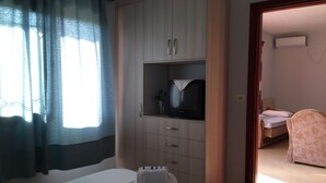 A hotel room with a bed, a wardrobe, a television, and a bathroom visible through an open door. - Prefect place to spend your holidays ! (Ksamil)