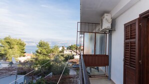 A balcony with a view of the sea, a wooden door, and an air conditioning unit. - A2 Large apt With the big Terrace & Great sea View (Trogir)