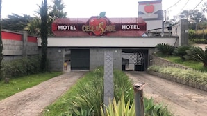 A building with a sign that reads "Motel Cequisabe Hotel" and a large apple logo. - Cequisabe Motel (Juiz de Fora)