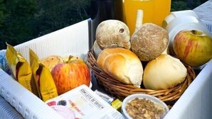 A tray with snacks and drinks on a balcony overlooking a forested landscape. - Cequisabe Motel (Juiz de Fora)