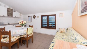 A compact living space with a dining area, a sofa, and a window with a view. - A1 Large apt With the big Terrace & Great sea View (Trogir)