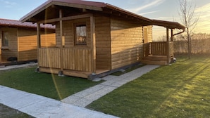 A wooden cabin with a porch, a window, and a door. - Chata pri Jazere 1 - Lake Side Cottage (Horná Potôn)