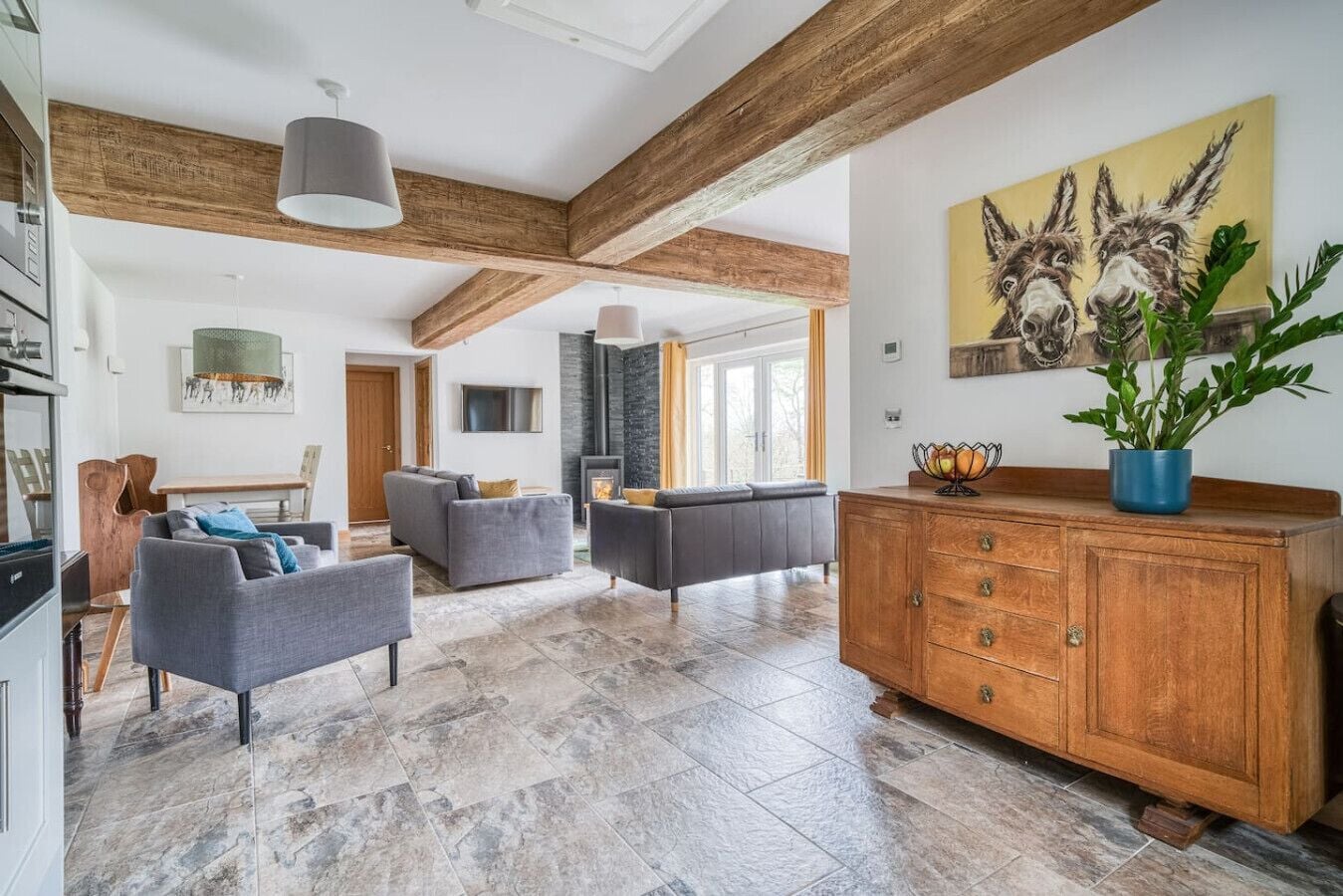 Ein geräumiger Wohnbereich mit Kamin, Sofas und einem Holzkabinett.