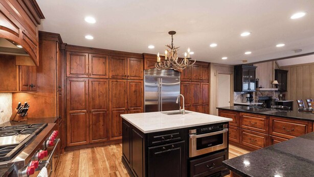 A kitchen with wooden cabinets, a stainless steel refrigerator, a built-in oven, and a central island with a sink. - NEWLY RENOVATED! Expansive 8,800 SF Luxury Home + Walkable to Beaver Creek Village + Hot Tub + Game Rooms (Beaver Creek)