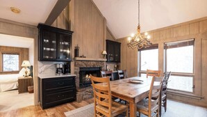 A cozy kitchen with a stone fireplace, wooden cabinets, and a dining table with chairs. - NEWLY RENOVATED! Expansive 8,800 SF Luxury Home + Walkable to Beaver Creek Village + Hot Tub + Game Rooms (Beaver Creek)