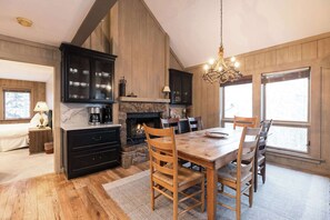 A cozy kitchen with a stone fireplace, wooden cabinets, and a dining table with chairs. - NEWLY RENOVATED! Expansive 8,800 SF Luxury Home + Walkable to Beaver Creek Village + Hot Tub + Game Rooms (Beaver Creek)