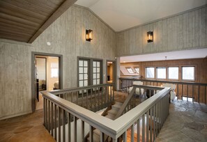 Stunning interior with high ceilings, exposed beams, and large windows.