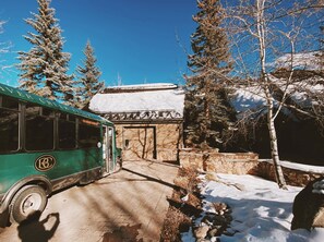 A green bus parked in front of a building with a snow-covered roof and stone walls. - NEWLY RENOVATED! Expansive 8,800 SF Luxury Home + Walkable to Beaver Creek Village + Hot Tub + Game Rooms (Beaver Creek)