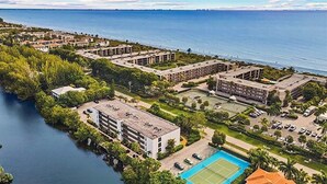 An aerial view of a coastal hotel with multiple buildings, a swimming pool, and a marina. - Sandpebble 2B (Sanibel)