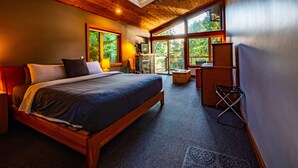 A spacious bedroom with a large bed, a TV, and a fireplace.