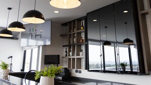 Een moderne receptiebalie met hanglampen, een receptie, een groot raam met uitzicht en een boekenkast.