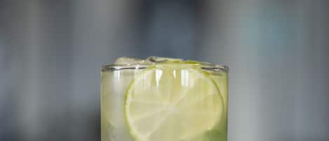 A tall glass with a lime slice and mint leaves, likely containing a beverage.