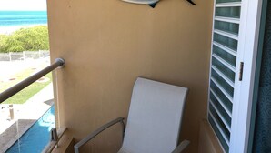 Un balcó amb una cadira, un peix decoratiu i vista a l'oceà.