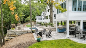 A residential property with a patio, outdoor seating, a barbecue area, and a swimming pool. - Traverse City Lakemore Resort, Side by Side Luxury Lakefront Homes on Arbutus Lk (Traverse City)