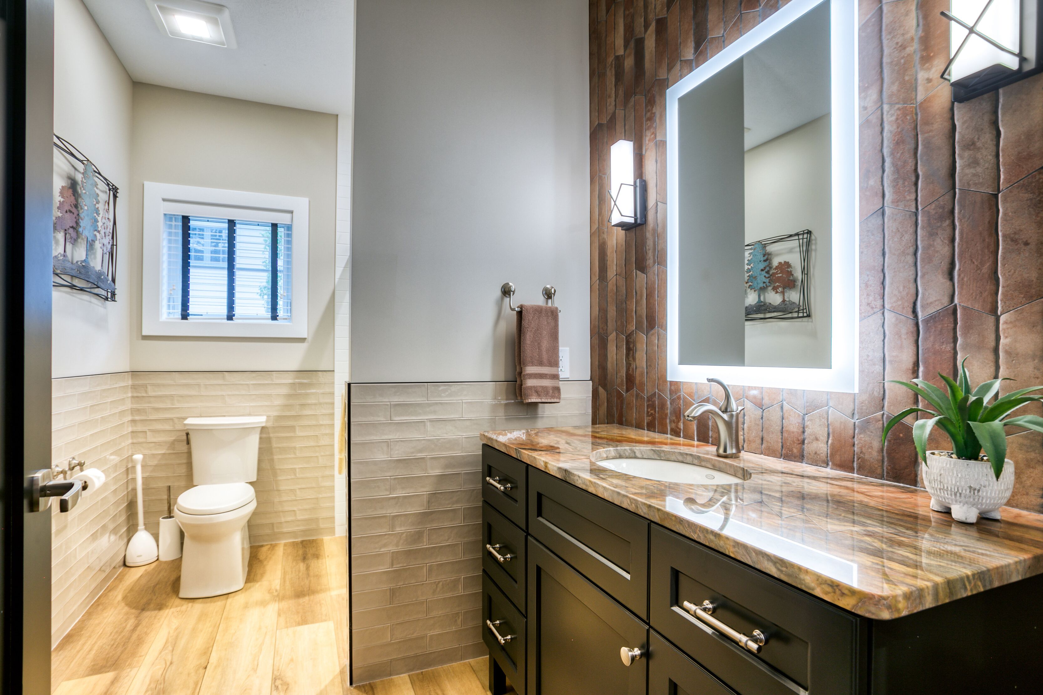A modern bathroom with a toilet, sink, and vanity.