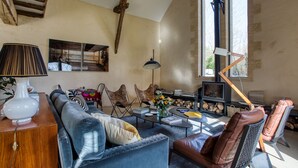 A cozy living room with a sofa, chairs, a coffee table, and a fireplace.