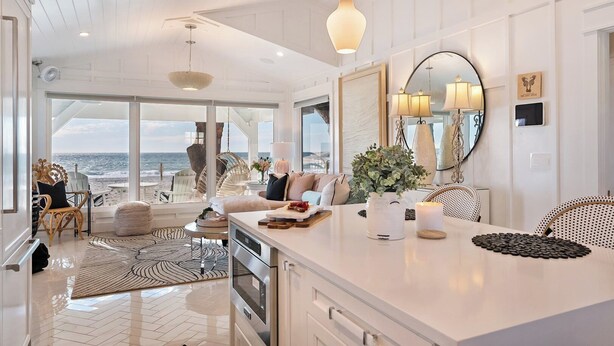 A spacious kitchen with a large island, a dining area with a view of the ocean, and a cozy seating area with a view of the beach. - The Love Shack: Completely restored 1915 direct beachfront cottage! (BRADENTON BEACH)