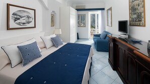Un dormitorio con cama, televisión y balcón.