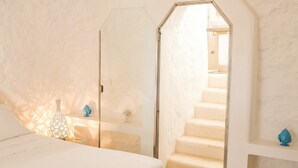A bedroom with a large bed, a glass door leading to a staircase, and decorative items on the nightstands. - Villa Paola - Cosy private villa near the sea (Monacizzo-librari-truglione)