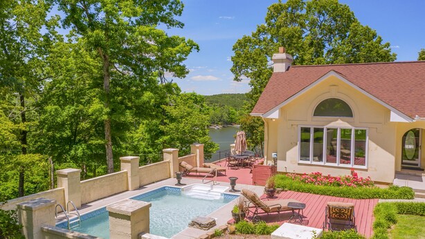 A pool with lounge chairs, a patio area with a table and chairs, and a view of a lake. - Yellowhammer Hill - Amenities galore! Near Cullman (Cullman)