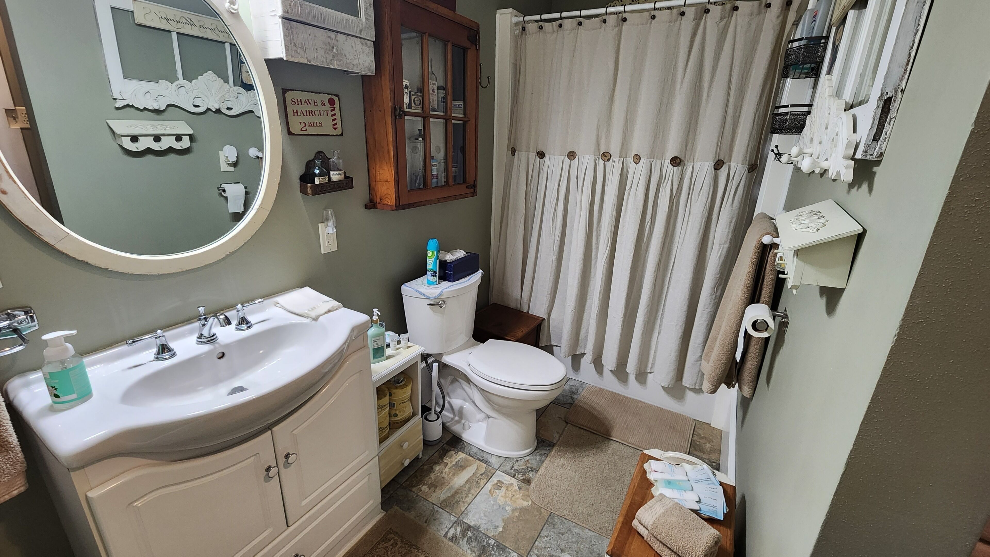 A bathroom with a sink, toilet, and shower curtain.