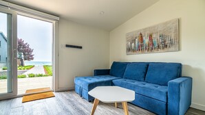 Ein modernes Wohnzimmer mit einem blauen Sofa, einem weißen Couchtisch und einem Stadtbild an der Wand.