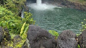 A waterfall surrounded by lush greenery and rocky terrain. - Private Studio, 10 min walk to Hakalau Beach, Hamakau Coast. 15 min to Honoli'i (Hakalau)