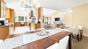 Amplia sala de estar con mesa de comedor, cocina y zona de estar.