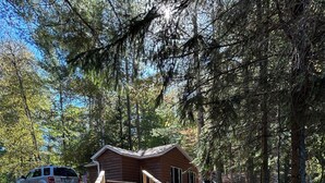 A wooden staircase leading to a cabin surrounded by trees. - Northwoods waterfront Rhinelander Cabin getaway (Rhinelander)