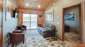A room with a wooden ceiling, a sofa, two armchairs, a small table, and a patterned rug. - The 4th Overlook Seeps 4, In-between Crystal Mountain and Traverse City! WI-FI  (Interlochen)