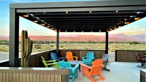 Une terrasse extérieure agrémentée de chaises Adirondack aux couleurs vives et offrant une vue sur les montagnes.