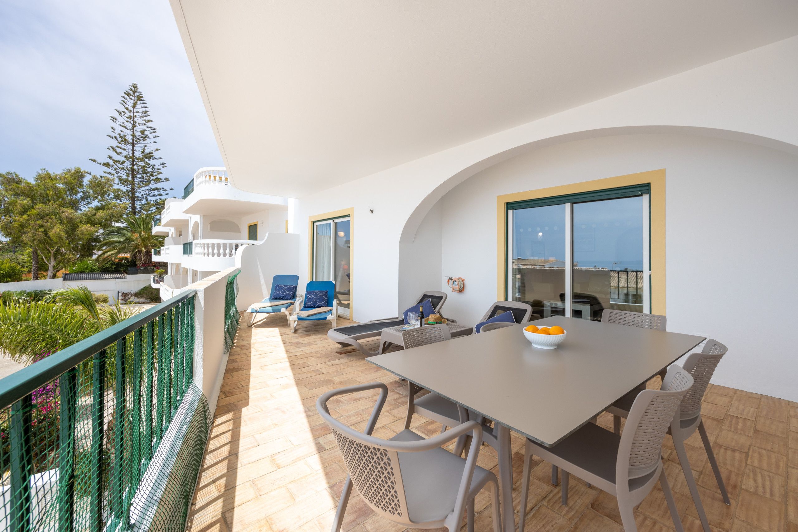 Un balcon avec une table à manger, des chaises et un ordinateur portable.