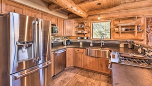 A modern kitchen with stainless steel appliances, wooden cabinetry, and a large island with a sink. - Riverfront Retreat w/ Hot Tub: Fish & Hike! (Buena Vista)