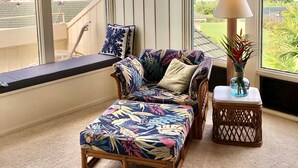 A cozy room with a large window, a cushioned bench, a small table with a lamp, and a decorative vase. - POIPU - ENJOY THE VIEWS!   
MANUALOHOA #506  w/NEW SPLIT A/C SYSTEM (Koloa)