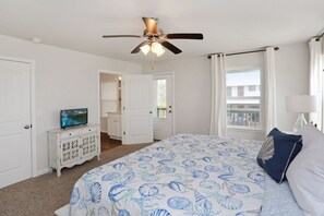 A bedroom with a bed, a ceiling fan, a TV on a dresser, and a window with curtains. - WindMark Beach, Community Pool, Playground, Short Walk to Beach ~ The Sandpiper (St. Joe Beach)