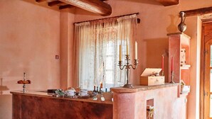 A cozy room with a marble counter, a window with floral curtains, and a wooden door. - Nice apartment for 2 guests with pool, WIFI, TV and balcony, close to Spoleto (Uncinano)