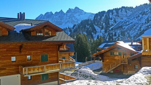 A wooden chalet with a balcony, surrounded by snow-covered mountains and clear skies. - Beautiful apartment for 4 people with WIFI, TV, balcony and pets allowed (Les Crosets)