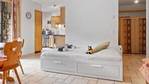 A compact bedroom with a bed, a small desk, and a chair. A kitchenette is visible in the background. - Beautiful apartment for 4 people with WIFI, TV, balcony and pets allowed (Les Crosets)